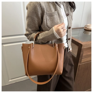Dettaglio di borsa in pelle marrone motivo litchi con eleganti finiture dorate