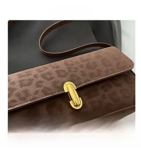 Dettaglio borsa scamosciata marrone con stampa leopardata e chiusura a girello dorata