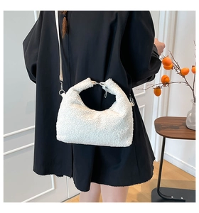 Borsa hobo minimalista bianca in lana d'agnello indossata da una modella in stile autunnale
