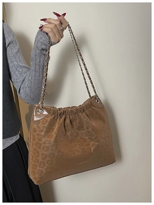 Detail of leopard print chain bag with Creative Cat logo and gathered suede texture