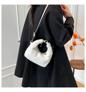 Dettaglio della borsa hobo in pile bianco con tracolla in pelle e fibbie metalliche