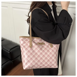 Dettaglio della borsa tote a scacchi rosa e bianchi con placca logo e tracolla marrone