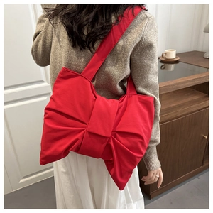 Dettaglio borsa tote in tela rossa con maxi fiocco e tracolla larga