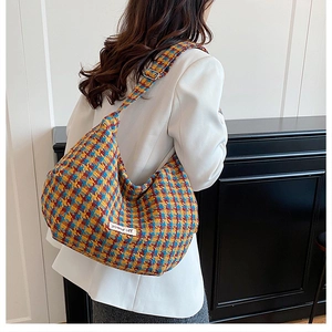 Detail of colorful tweed hobo bag with adjustable strap and power off woven label
