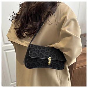 Dettaglio borsa leopardata sottobraccio con fibbia dorata su trench color kaki