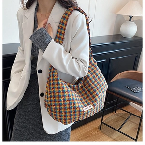 Detail of colorful plaid tweed tote bag showing fabric texture and woven patterns