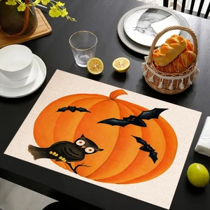 Detail of Halloween linen placemat featuring orange pumpkin and black owl on a table
