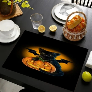 Detail of Halloween placemat with black cat and pumpkin pattern on a set dining table