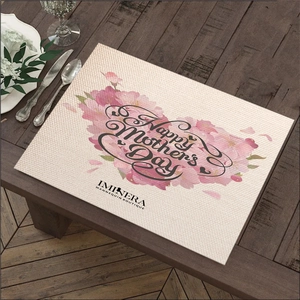 Linen placemat with cherry blossoms and Happy Mother's Day text on wooden table