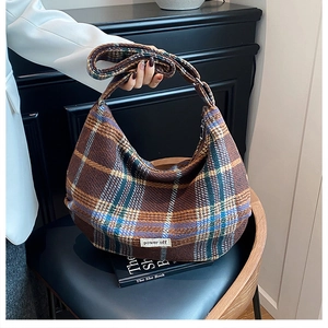 Close-up of retro plaid hobo bag in brown wool fabric on a leather seat