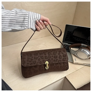 Dettaglio di una borsa a spalla leopardata marrone con chiusura in metallo dorato