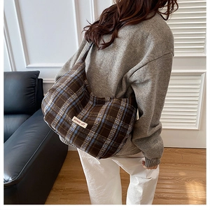 Detail view of brown plaid woolen crossbody bag with 'power off' patch decoration