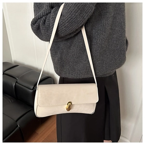 Dettaglio della borsa sottobraccio in pelle beige con chiusura a scatto dorata