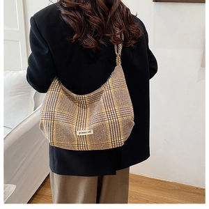 Detailed view of hobo bag featuring yellow plaid pattern and power off label logo