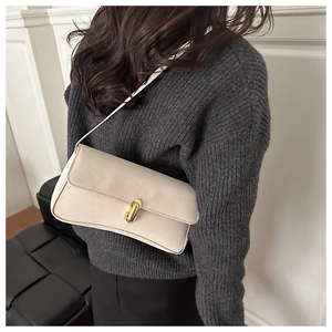 Dettaglio della borsa beige con elegante chiusura a scatto in metallo dorato e pelle opaca
