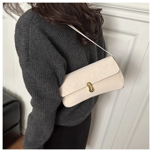 Dettaglio della borsa baguette in pelle bianco crema con chiusura in metallo dorato