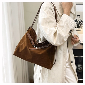 Dettaglio della grande borsa tote in pelle scamosciata marrone con cinturini in pelle