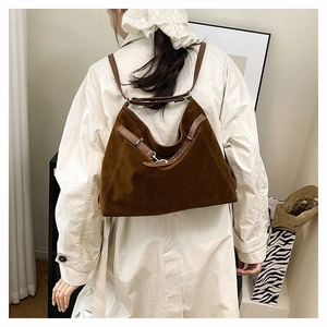 Dettaglio della borsa tote in pelle scamosciata marrone con cinturini in pelle