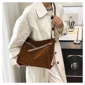 Dettaglio della borsa Hobo in pelle scamosciata marrone scuro con fibbia in pelle e tracolla