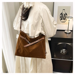 Dettaglio della borsa tote in pelle scamosciata marrone con cinturini con occhielli
