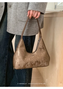 Dettaglio borsa hobo color bronzo con finitura metallica spazzolata e logo stampato