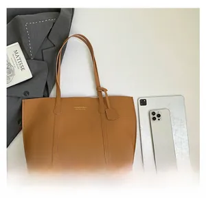 Flat lay of a large brown textured PU leather tote bag with elegant gold lettering detail