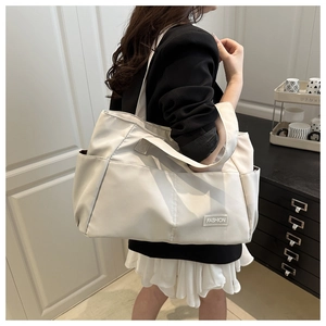 Dettaglio della borsa tote in nylon avorio con etichetta moda e tasca esterna da donna