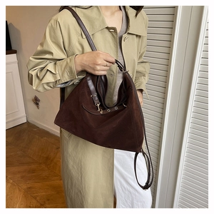 Dettaglio borsa tote in pelle scamosciata marrone con tracolla in pelle e gancio oro