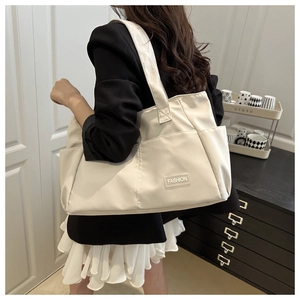 Dettaglio della grande borsa tote bianca con toppa FASHION e robuste tracolle