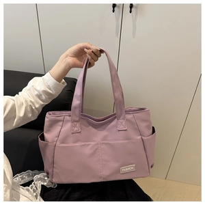Dettaglio della borsa tote in tela lavanda con tessuto resistente e logo Fashion