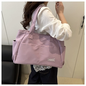 Vista laterale di una borsa tote in nylon viola capiente con tasca laterale