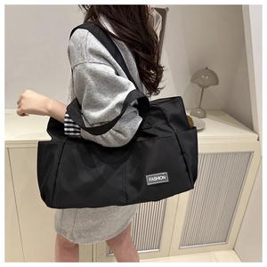 Dettaglio della borsa tote in nylon nero con etichetta argentata Fashion cucita