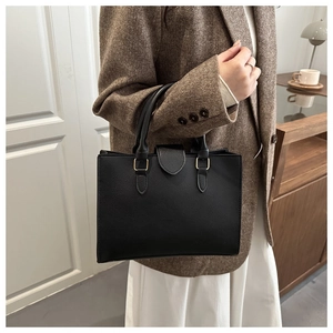 Dettaglio della borsa nera in pelle PU con grana litchi e fibbie in metallo dorato
