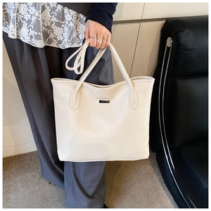Dettaglio della borsa tote beige con grana litchi, fibbia argento e tracolla regolabile