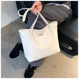 Dettaglio della borsa tote crema in pregiata pelle a grana litchi con placchetta in metallo