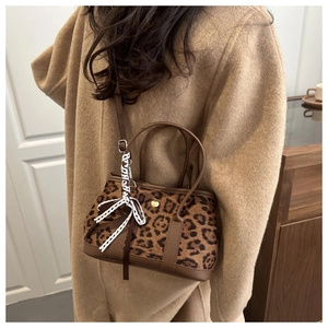 Dettaglio borsa leopardata in peluche con finiture in pelle e ciondolo cuore dorato