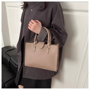 Dettaglio della borsa tote beige in pelle martellata con raffinati inserti in metallo dorato