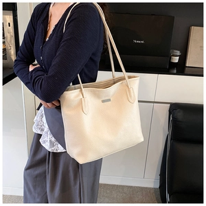 Vista dettagliata della borsa tote in pelle litchi bianco crema con sottili tracolle