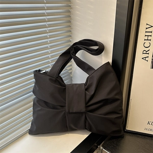 Borsa tote nera minimalista con grande fiocco decorativo sul davanzale della finestra