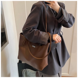 Dettaglio borsa tote in pelle martellata marrone scuro con placchetta argentata