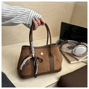 Dettaglio borsa tote in pelle scamosciata marrone con finiture in pelle e pizzo di seta