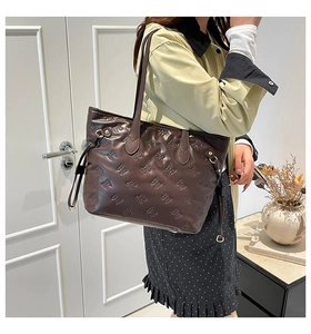 Dettaglio della borsa tote in pelle marrone scuro con goffratura fiocchi 3D e coulisse