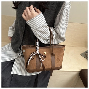 Dettaglio mini borsa tote vintage in pelle scamosciata marrone con nastro e bottone in metallo
