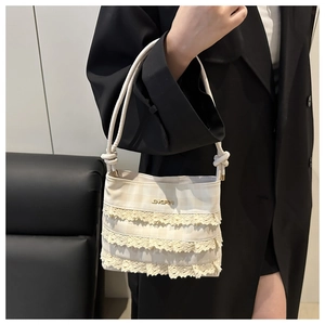Dettaglio della borsa tote in pizzo bianco con logo JINGPIN e manici annodati