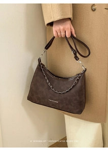 Dettaglio borsa a mezzaluna vintage con trama in pelle martellata e catena in metallo
