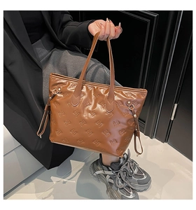 Borsa tote marrone con trama a fiocchi e coulisse laterale indossata da modella