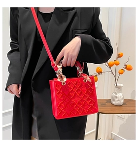 Dettaglio borsa trapuntata rossa con rilievo corona, hardware dorato e foulard in seta