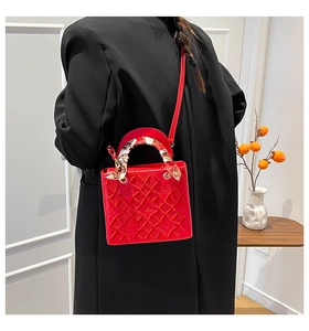 Dettaglio borsa quadrata rossa goffrata con manico a foulard di seta e tracolla sottile