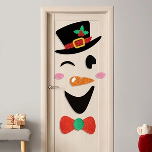 Dettaglio di adesivi natalizi glitterati per porta con cappello nero e fiocco rosso