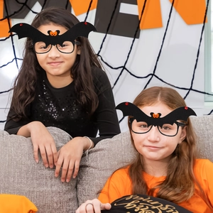 Children wearing black bat-shaped Halloween glasses with orange bows and red accents